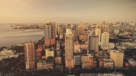 Slow motion skyscrapers cityscape at ocean bay aerial. Metropolis port city sun light landscape. Philippines capital town of Manila at sunlight summer day. Downtown buildings at sea gulfの写真素材