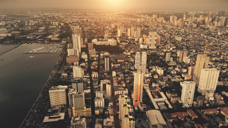 Metropolis city at sea bay sunrise aerial. Philippines capital cityscape at sun rise light. Urban streets with modern buildings at roads, highways. High skyscrapers at sunlight. Cinematic summer townの写真素材