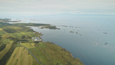 Alcohol industy at sea bay aerial. Whiskey distillery at countryside. Green forest and fields at rural farmlands. Nobody nature landscape. Port town Ellen, Islay Island, United Kingdom, Europeの写真素材