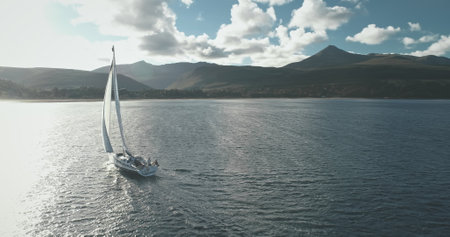 Sun sea bay with yacht regatta aerial. Serene seascape with luxury sailboat reflection at ocean gulf. Summer vacation on sail boat cruise. Tourism and travel concept. Cinematic soft light drone shotの写真素材
