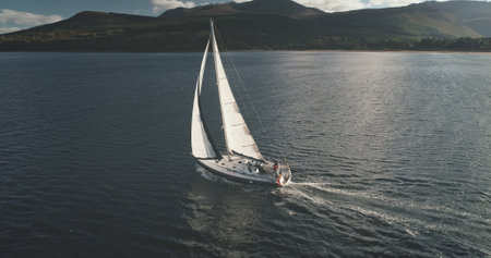 Sun light at sea bay with luxury yacht reflection aerial. Epic passenger sailboat cruise at open ocean. Tourism and travel lifestyle. Summer vacation scenery at sunshine. Cinematic seascapeの写真素材