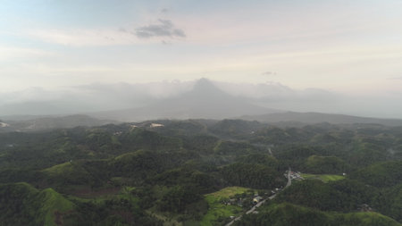 Aerial view of cityscape at hillside village. Small cottages at rural road admist hilly greenery landscape with tropical plants. Contryside urban scenery Legazpi town, Albay province, Philippine, Asiaの写真素材