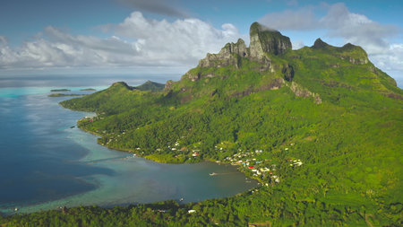 Breathtaking aerial view of Bora Bora island lagoon showing its lush green vegetation, turquoise coral reef, and majestic mount Otemanu. Aerial drone shot. French Polynesia travel tropical paradiseの写真素材
