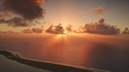 French Polynesia, Rangiroa island: Aerial view stunning golden sunset over Rangiroa, French Polynesia, sunbeams cloudy sky over ocean and land. Wild nature travel landscape. Drone flightの写真素材