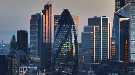 United Kingdom, London: Aerial view of Londons financial district at sunset, featuring modern skyscrapers and iconic landmarks against a vibrant sky. Drone flightの写真素材