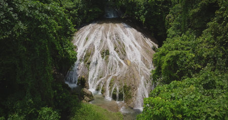 Fiji, Port Villa: Aerial drone of stunning cascade waterfall flowing through a vibrant tropical green rainforest on Efate Island. Vanuatu. Wild nature landscape, travel background.の写真素材