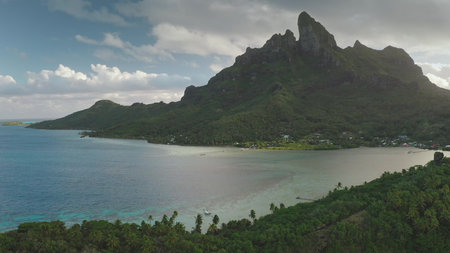 Majestic mount otemanu dominates bora bora islands skyline, its verdant slopes meeting the crystal-clear turquoise waters of a tranquil lagoon, creating a breathtaking tropical panoramaの写真素材