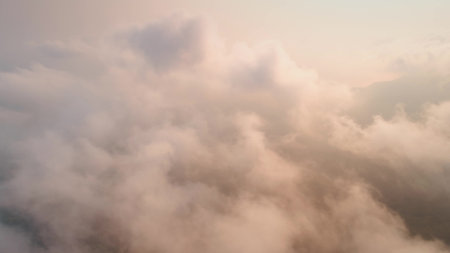 Capturing a breathtaking aerial view of fluffy cloudscapes during sunset, creating a serene...
