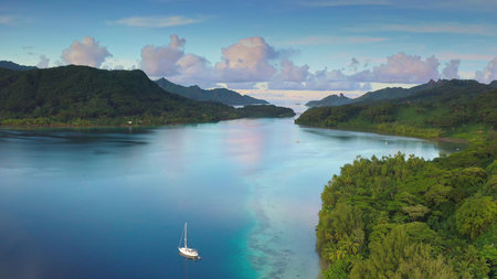 Aerial view sailboat enjoying a peaceful morning in a turquoise lagoon surrounded by lush tropical...