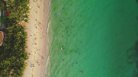 Cagban Beach in Boracay, Philippines, seen from above, with tourists swimming, sunbathing, and...
