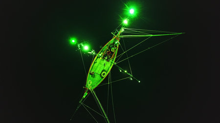 Low angle night view of a squid fishing boat using green lights to attract its prey, creating a...