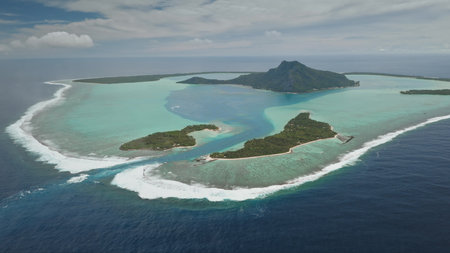 Aerial view panorama of Maupiti, volcanic island surrounded by turquoise lagoon and coral reef motu ocean, creating breathtaking tropical landscape in French Polynesia. Remote wild nature paradiseの写真素材