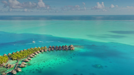 Luxurious overwater bungalows resort in French Polynesia, tropical paradise, yacht sails turquoise...