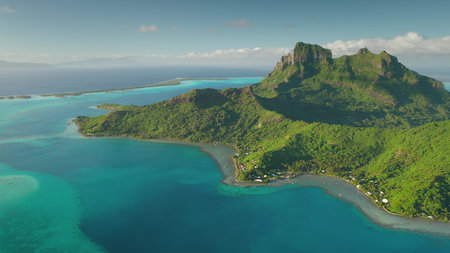 Aerial drone flight over breathtaking beauty of Bora Bora, French Polynesia, mount Otemanu, lush greenery, and vibrant turquoise lagoon. Wild travel destination, remote exotic summer nature paradiseの写真素材