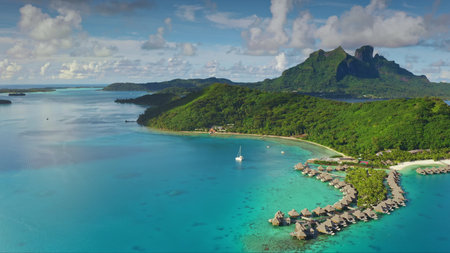 Turquoise lagoon water, overwater bungalows and green hills mountains of Bora Bora tropical island...