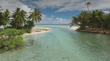 Drone fly between two small sandy islands with crystal clear water lagoon channel bay. Green palm...
