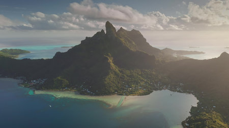 Sunset over Bora Boras turquoise lagoon and iconic mount otemanu towering over south pacific ocean water. Dramatic beauty of French Polynesia. Remote wild nature scene, travel background. Aerial viewの写真素材