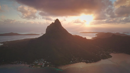 Aerial view of mount otemanu under bright colorful sunset sky. Tropical Bora Bora island mountain peak silhouette against orange cloudscape. Perfect wild nature landscape, travel background drone shotの写真素材