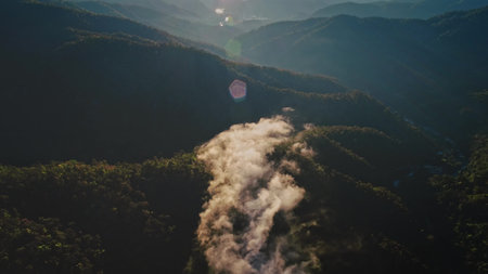 Aerial view of morning mist flowing between forested mountains in Chiang Mai Province, Thailand,...