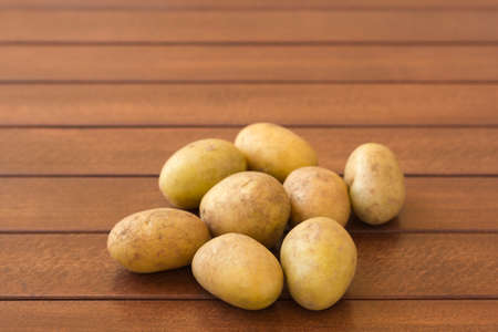 Raw potatoes on wooden backgroundの写真素材