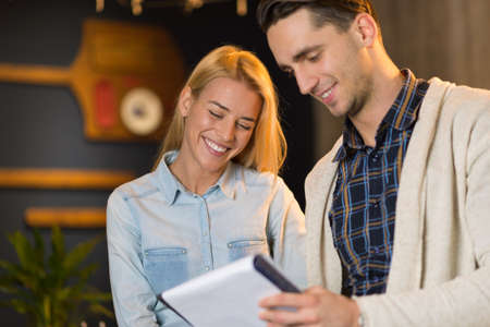 Two young business colleagues working together on paperworkの写真素材