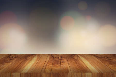 Wooden table in front of abstract blurred lights backgroundの写真素材