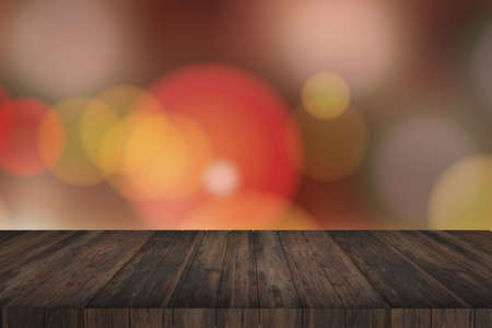 Wooden table in front of abstract blurred lightsの写真素材
