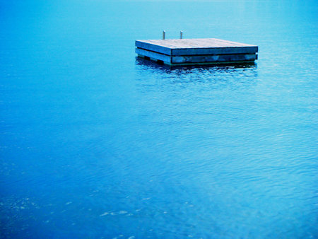 A swimming raft floating in calm blue lake water.の写真素材