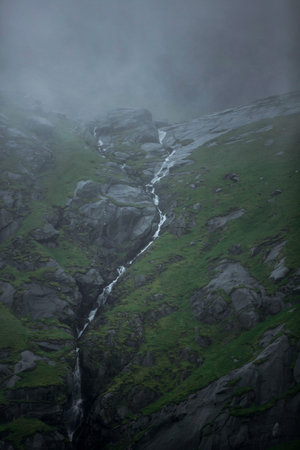 waterfall in the mountains of Norway on a foggy day