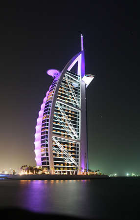 Dubai's Burj Al Arab glowing in the night sky.のeditorial素材