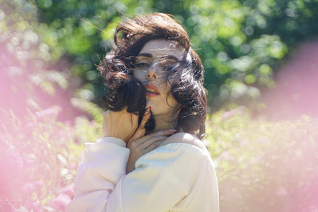 Closeup face of mature woman enjoying the sun at the city park. Beautiful lady relaxing near the...