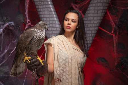 beauty brunette girl and a hawk on dark gothic scary studio background