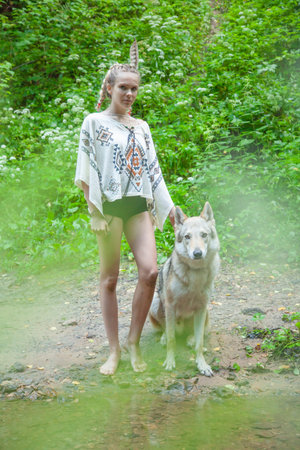 slim ethnic girl with her wolf dog in the deep forest alone