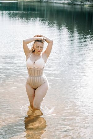 plus size woman with curvy figure in corset lingerie. caucasian xxl chubby girl wanna swimming.の写真素材