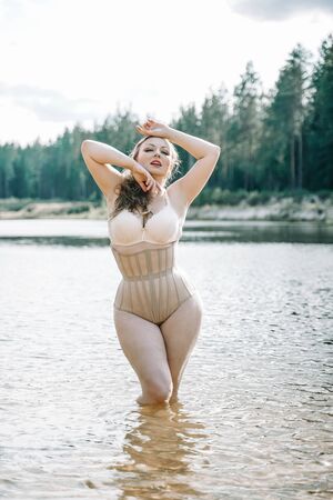 plus size woman with curvy figure in corset lingerie. caucasian xxl chubby girl wanna swimming.の写真素材