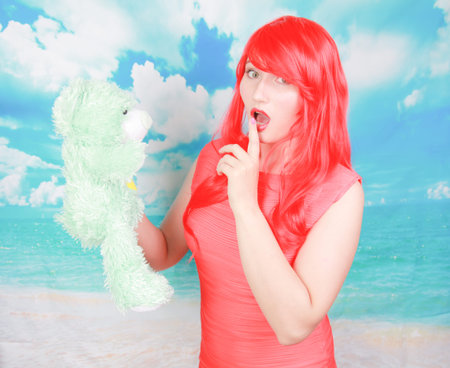 redheaded adult woman punish little cute teddy bear toyの写真素材