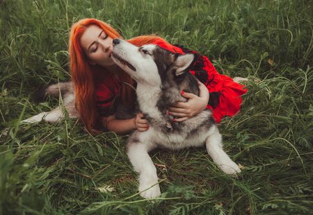 Girl with big grey dog on the nature background at summer time. Lifestyle photo.の写真素材