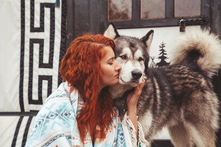 girl with her dog Malamute near round home far away from civilization in the woodsの写真素材