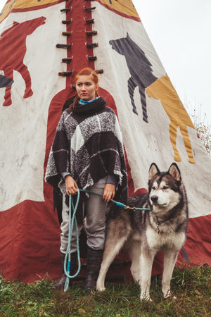 cute adult girl owner with her malamute gray big dog in the Injun camping