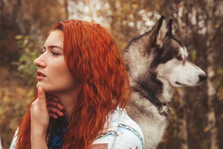 redhaired caucasian woman owner with her malamute grey big dogの写真素材