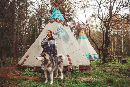 redhaired caucasian woman owner with her malamute grey big dog in the campingの写真素材