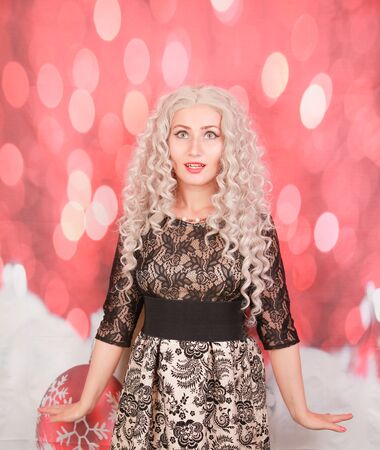 caucasian gorgeous women in trendy black lace dress on red backgroundの写真素材
