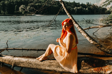 cute redheaded girl walking in the summer hot city parkの写真素材
