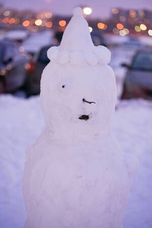 cute snowy snowman in the evening at the christmas city with nobodyの写真素材