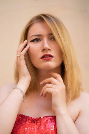 blonde girl with wide make up arrows on the eyes posing in the streetの写真素材