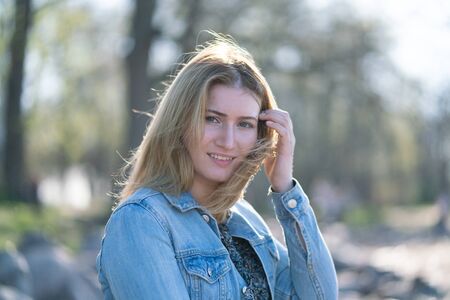 pretty woman relaxing by walking in the city park in jeans outfitの写真素材