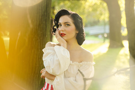 young beautiful caucasian woman posing in retro styling. pin up girl in white shirt at sunset...