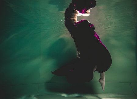 young woman swimming alone with fashion fabric underwater incognito