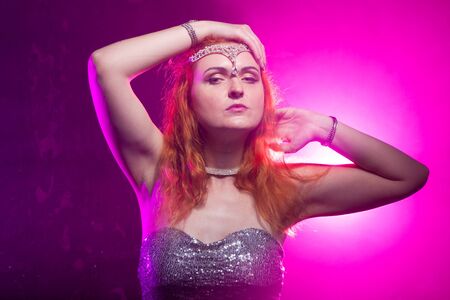 Mature plus size red hair woman in grey evening dress posing on dark smoke background ready for halloween.の写真素材