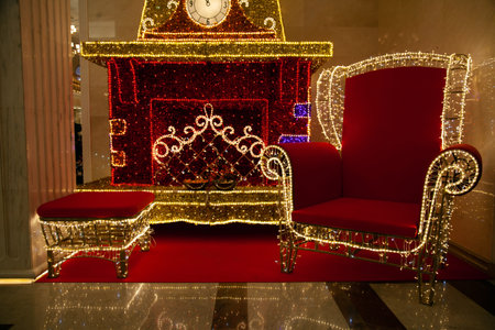 Santas chair surrounded by presents and christmas treeの写真素材